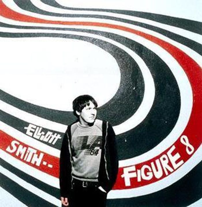Picture of Figure 8's Album cover: Elliot Smith standing in front of a wall painted with red and black wavy lines