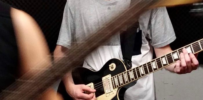 Photo of a colleague from work playing a black Gibson Les Paul guitar